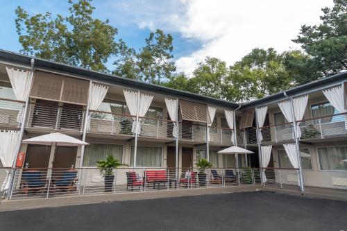 an exterior view of a building with tables and umbrellas at City Loft Hotel in Beaufort