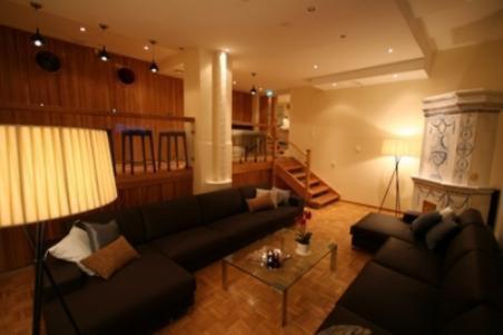 a living room with a couch and a fireplace at Hotel Homeland in Tampere