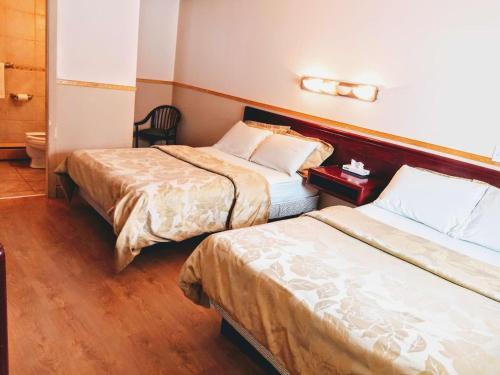 a hotel room with two beds and a chair at Hotel Motel La Marquise in Sherbrooke