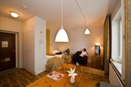 a living room with two people sitting on a couch at Hotel Homeland in Tampere