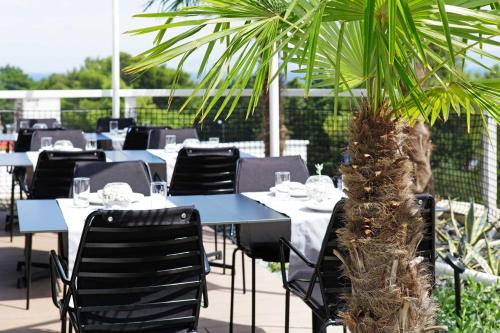 a restaurant with tables and chairs and a palm tree at Lifestyle Hotel Vitar - Adults Only in Bol