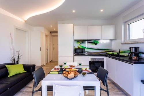 a kitchen and living room with a white table and chairs at Villa Valis in Baška