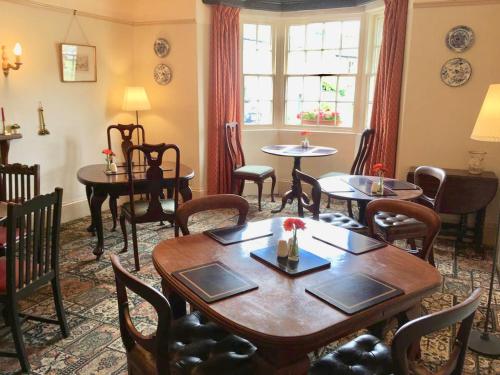 uma sala de jantar com mesas e cadeiras e uma janela em The Falcon Inn em Arncliffe
