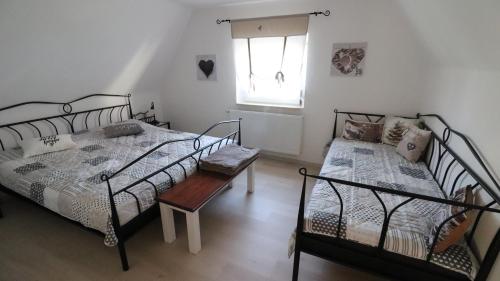 a bedroom with two beds and a table and a window at Ferienhaus Steinbach in Oberasbach