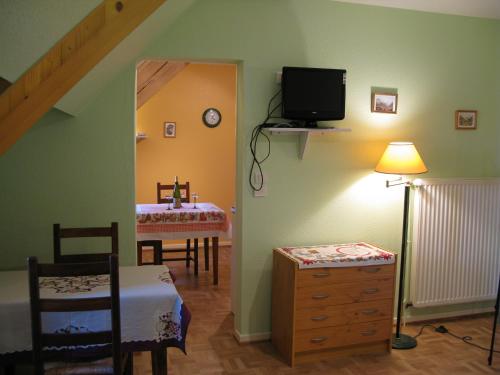 une chambre avec une table et une télévision dans l'établissement Gites Les Cépages, à Ammerschwihr