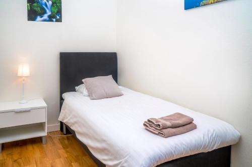 a bedroom with a bed with two towels on it at Hotell Linden in Östersund
