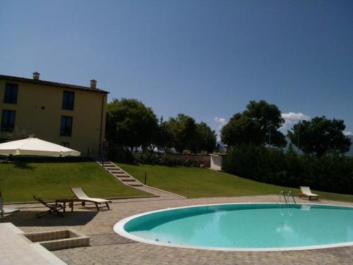 une piscine avec deux chaises et un bâtiment dans l'établissement Villa Giovina, à Pratola Peligna