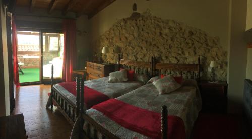 A bed or beds in a room at Posada Rural El Trenti de Corona