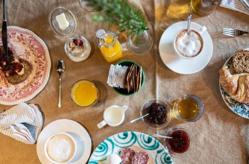 a table with plates of breakfast foods and drinks at Foresteria San Rocco Borgoluce in Susegana