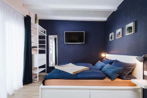 a bedroom with blue walls and a bed with blue pillows at Rostocker Stadtidyll in Rostock