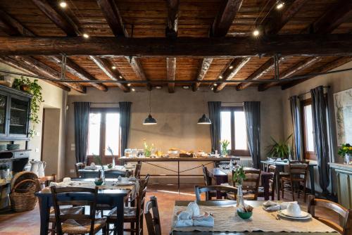 un ristorante con soffitti e tavoli in legno e sedie di Foresteria Borgoluce a Susegana