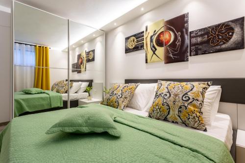 a bedroom with a green bed and a mirror at Villa Valis in Baška