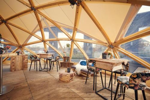 a room with large windows and tables and chairs at Van der Valk Hotel Brussels Airport in Diegem