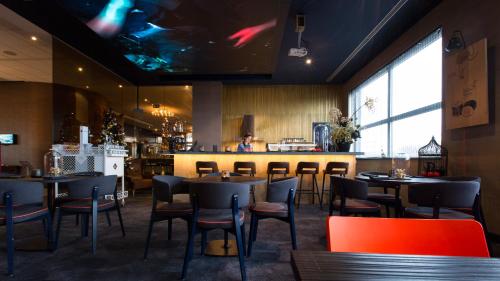 a restaurant with tables and chairs and a bar at Van der Valk Hotel Brussels Airport in Diegem