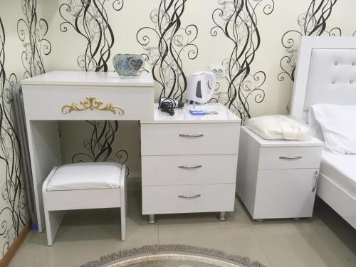 a white dresser and a stool in a bedroom at Hotel Triumph in Ninotsminda
