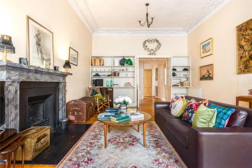 a living room with a couch and a fireplace at GRAND & SPACIOUS CENTRAL APT WITH WiFi in Edinburgh