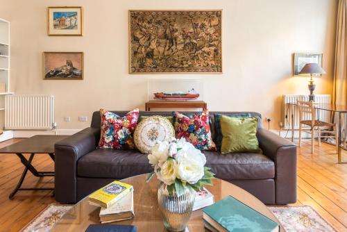 a living room with a couch and a table at GRAND & SPACIOUS CENTRAL APT WITH WiFi in Edinburgh