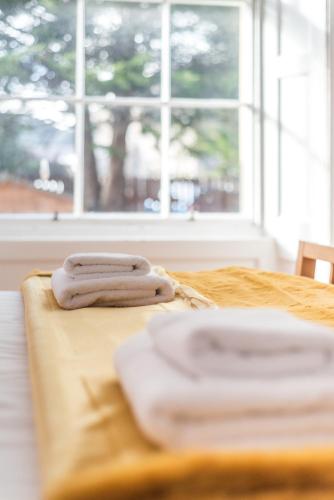 two towels sitting on top of a bed with a window at GRAND & SPACIOUS CENTRAL APT WITH WiFi in Edinburgh