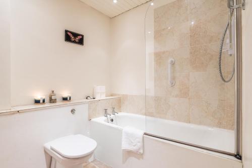 a bathroom with a shower and a tub and a toilet at GRAND & SPACIOUS CENTRAL APT WITH WiFi in Edinburgh