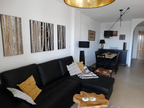 sala de estar con sofá negro y mesa en Apartment in Campoamor en Campoamor