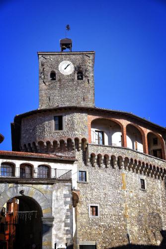 a building with a tower with a clock on it at Villa Belvedere in Pieve Fosciana
