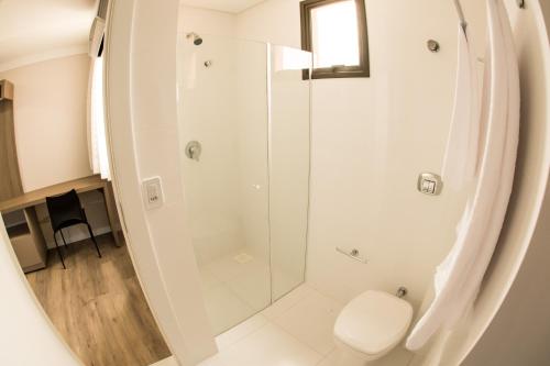 uma casa de banho com um chuveiro e um WC. em Laranjeiras Palace Hotel em Laranjeiras do Sul