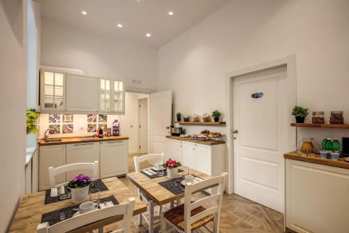 una cucina con tavolo e sedie in legno in una stanza di Sorrento Square Suites a Sorrento