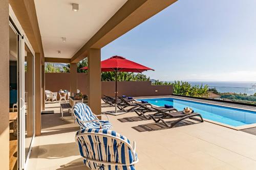 a patio with chairs and a swimming pool at NEW! Villa Alvinho| Lifestyle&Nature | Heated Pool in Funchal