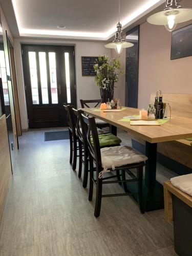 a kitchen with a large wooden table with chairs at Penzion Na Solné stezce in Kašperské Hory