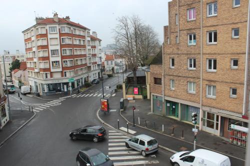 uma rua da cidade com carros estacionados na rua em Studios Galaxia em Fontenay-sous-Bois