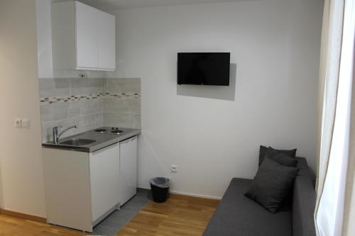 a kitchen with a sink and a couch in a room at Studios Galaxia in Fontenay-sous-Bois