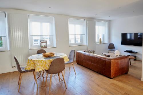 a living room with a table and a couch at Les Appartements Saint-Michel - centre-ville 2 chambres 90m2 avec garage in Saint-Brieuc