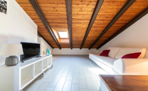 - un salon avec un canapé et une télévision dans l'établissement Residenza Ariosto Depandance by Studio Vita, à Bologne