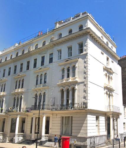 a large white building on a city street at Kensington Gardens in London
