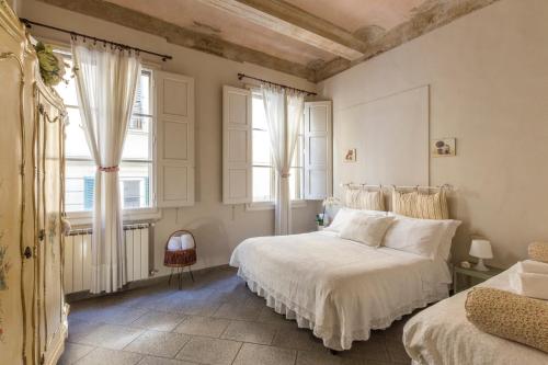 1 dormitorio con 2 camas y 2 ventanas en Casa Laura&Duccio en Florence