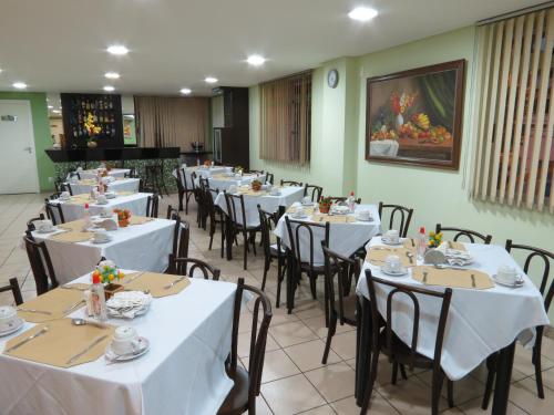 伊帕廷加斯蒂尔山谷经济型酒店的一间设有白色桌椅的餐厅,