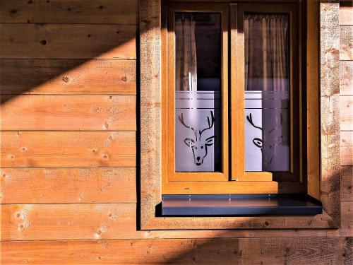 a window with two cups with deer heads on it at Feriendorf X-Alp Lodges Ötztal in Sautens