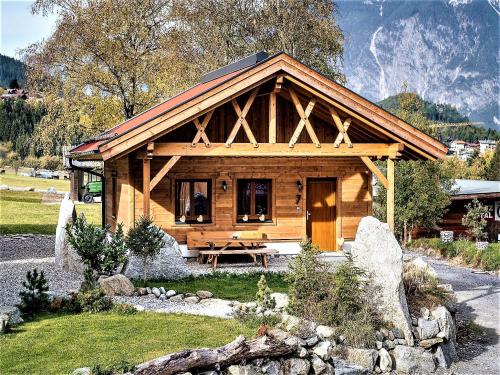 a log cabin with a picnic table in front of it at Feriendorf X-Alp Lodges Ötztal in Sautens