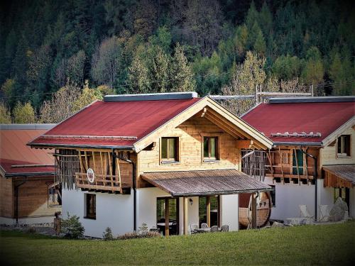 a wooden house with a red roof at Feriendorf X-Alp Lodges Ötztal in Sautens