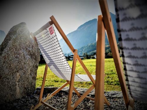 a white chair sitting next to a rock at Feriendorf X-Alp Lodges Ötztal in Sautens
