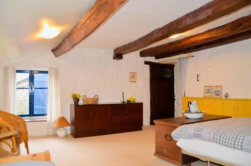 1 dormitorio con cama y tocador de madera en Chez Nous, en Isches