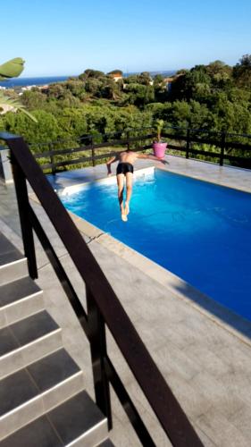 a person jumping into a swimming pool at Au bien être in Bastia