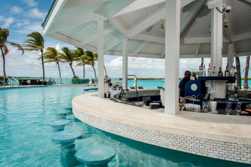 a bar on the edge of a pool at a resort at Blue Haven Resort- All Inclusive in Grace Bay