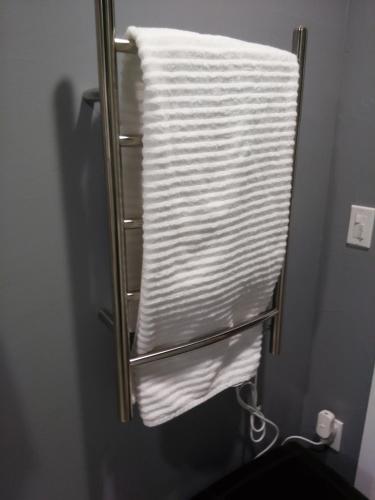 a towel rack with a stack of towels in a bathroom at Off Broadway B & B in Denver