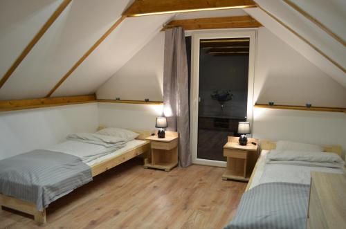 two beds in a attic room with two lamps at Willa Słowianka in Polanica-Zdrój
