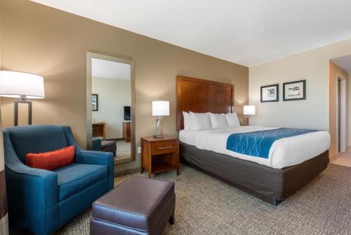 a hotel room with a bed and a chair at Comfort Inn & Suites Tavares North in Tavares