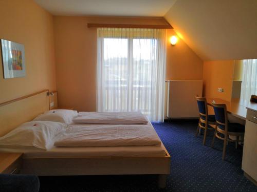 シュテガースバッハにあるKunstcafe Roomsのベッドと窓が備わるホテルルーム