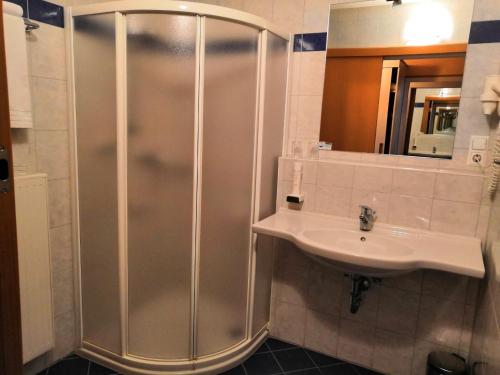La salle de bains est pourvue d'une douche et d'un lavabo. dans l'établissement Kunstcafe Rooms, à Stegersbach