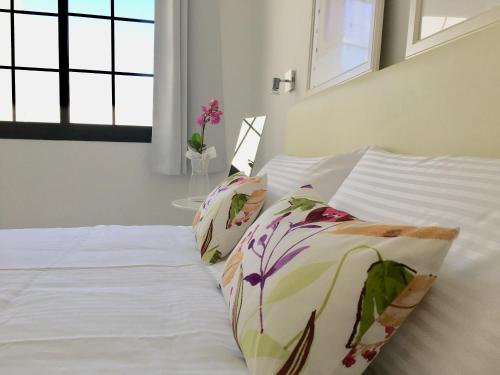 a bed with two pillows on it in a bedroom at Apt BARLOVENTO. Near the beach in Tías