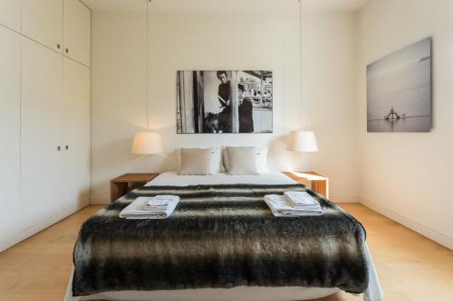 a bedroom with a large bed with a faux fur blanket at FLH Chiado Design Flat in Lisbon